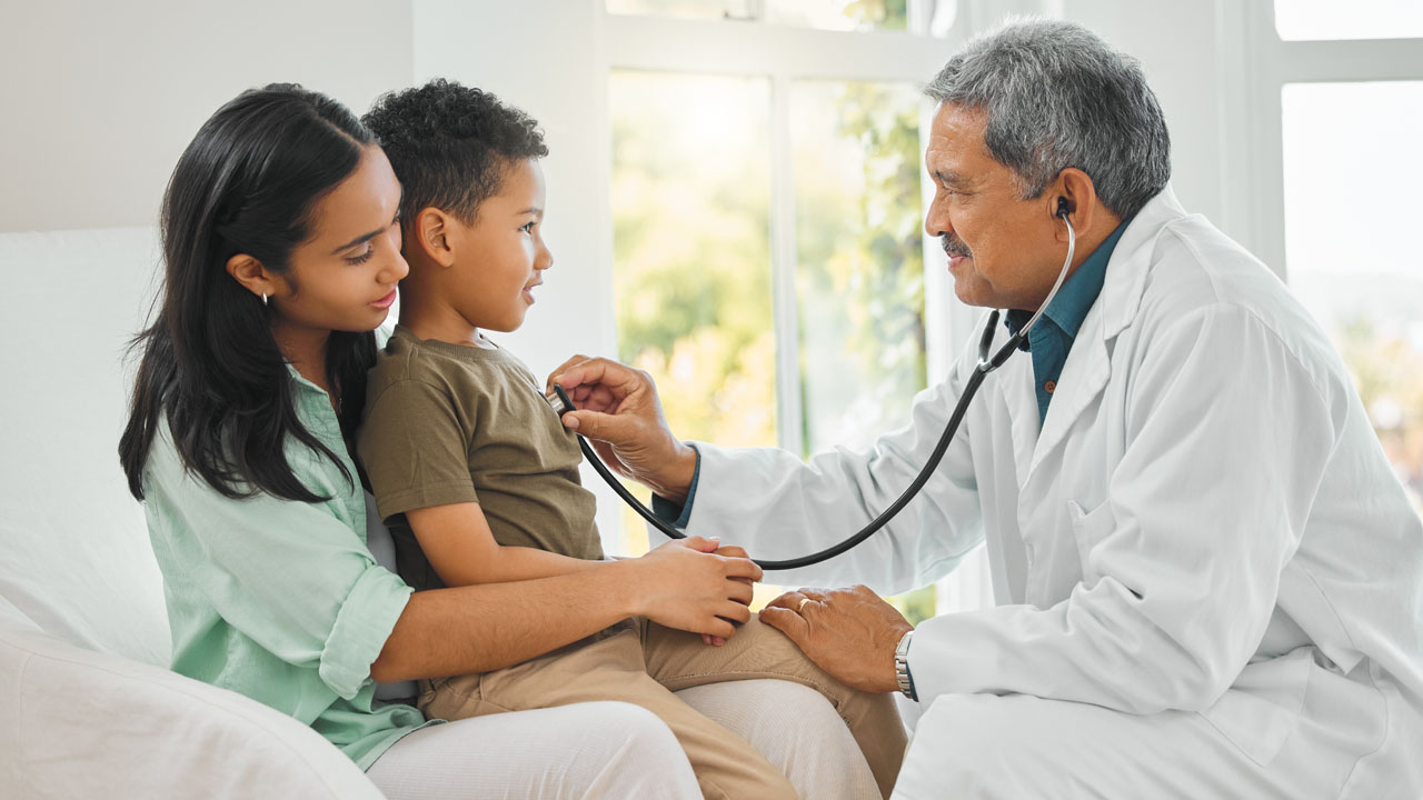 A male doctor checking upon his young boy patient